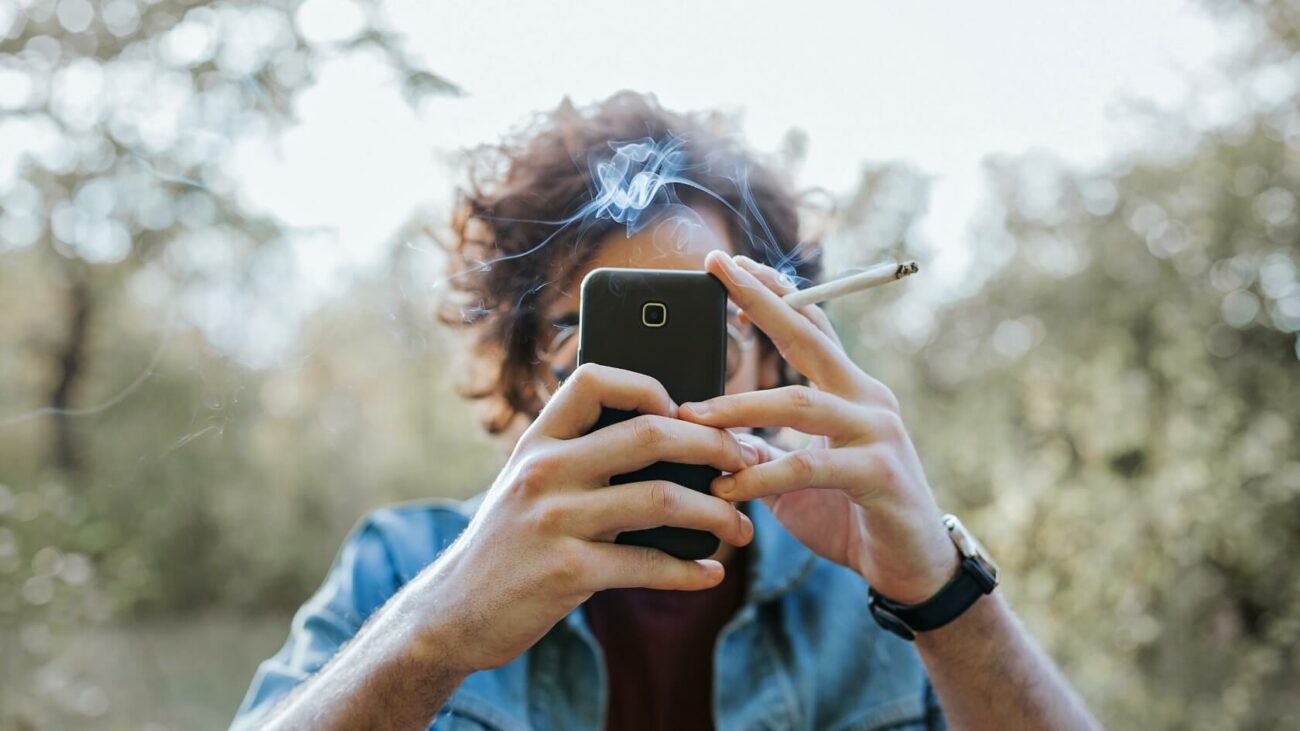 Person smoking while looking on his phone